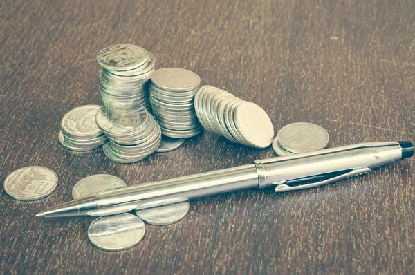 Pen and coins with filter effect retro vintage style — Stock Photo, Image