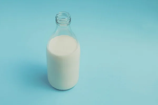 Com leite no fundo azul com efeito de filtro estilo vintage retro — Fotografia de Stock