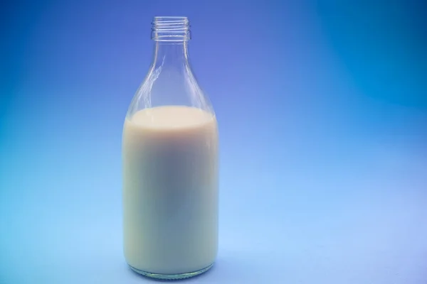 Com leite no fundo azul com efeito de filtro estilo vintage retro — Fotografia de Stock