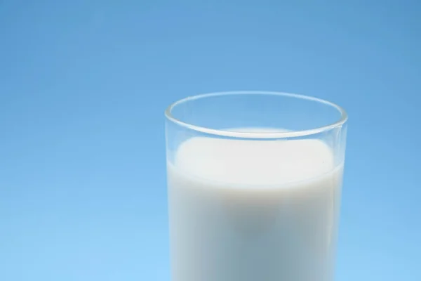Com leite sobre fundo azul — Fotografia de Stock