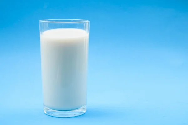 S mlékem na modrém pozadí — Stock fotografie