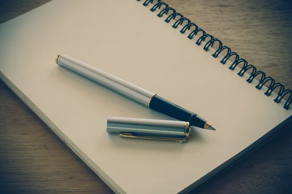 Notizbuch und Stift auf einem Tisch mit Filtereffekt Retro-Vinta — Stockfoto