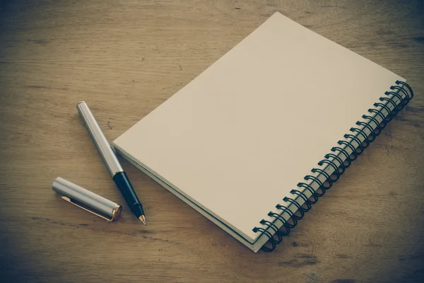 Σημειωματάριο χαρτί και στυλό σε ένα τραπέζι με φίλτρο αποτέλεσμα ρετρό vinta — Φωτογραφία Αρχείου