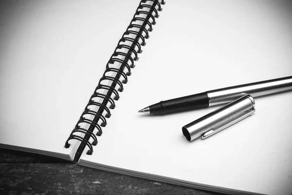 Caderno de papel e caneta em uma mesa com efeito de filtro retro vinta — Fotografia de Stock