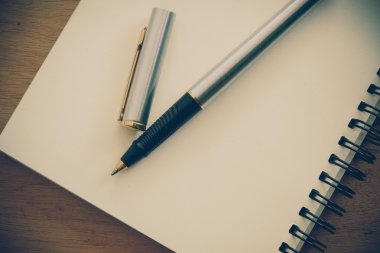 Kağıt defter ve kalem filtre etkisi retro vinta bir masada