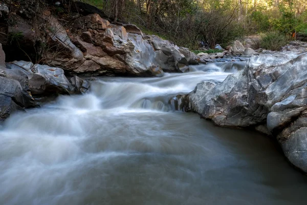 ลําธารที่ไหลผ่านหิน — ภาพถ่ายสต็อก