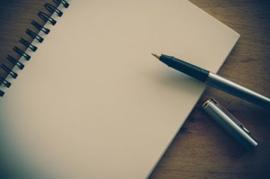 Kağıt defter ve kalem filtre etkisi retro vinta bir masada
