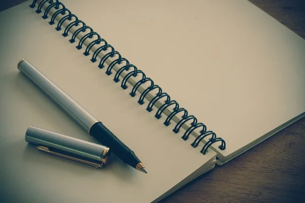 紙のノートとフィルター効果のレトロなヴァルのテーブルの上のペン — ストック写真