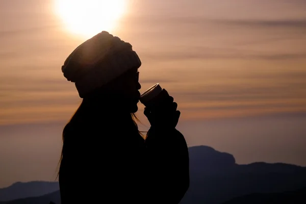Een warm drankje drinken bij zonsondergang — Stockfoto