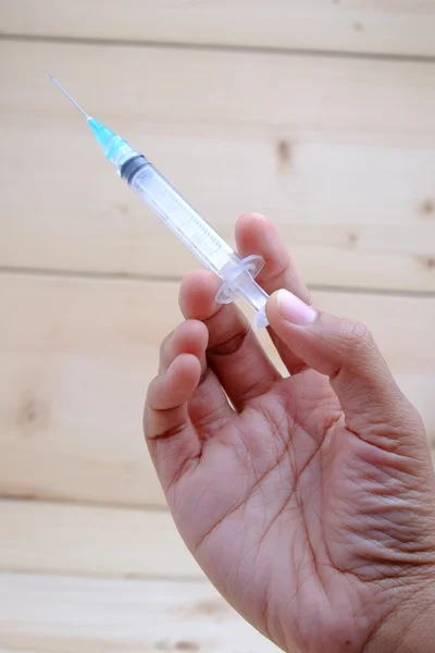 Hand holding syringe with filter effect retro vintage style — Stock Photo, Image