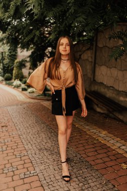 Açık havada mini etekli genç bir kadın. Moda 2021 yazı. Göz kamaştırıcı.