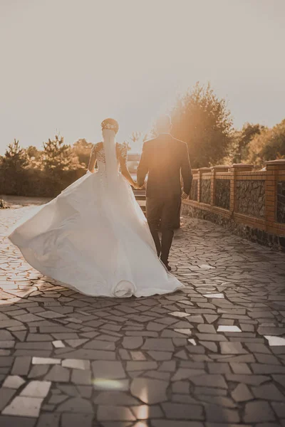 Het bruidspaar loopt weg naar de zonsondergang. — Stockfoto