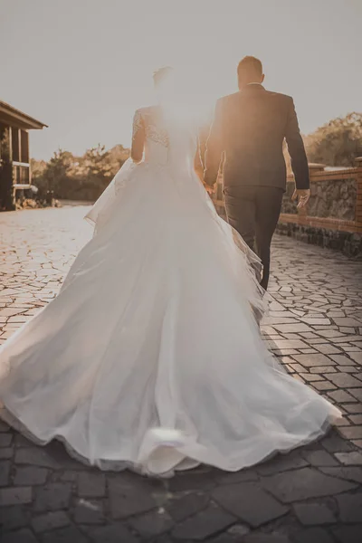The wedding couple runs away into the sunset
