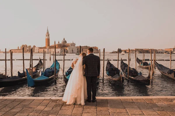 Um casal de casamentos está no cais em Veneza. Barcos flutuar no wate — Fotografia de Stock