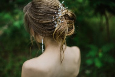 Uzun saçlar için kadın saç stili. Süslü, takılı topuz.