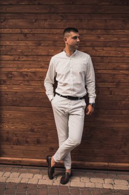 İş kıyafetleri içinde genç bir adam moda kıyafeti giyiyor.