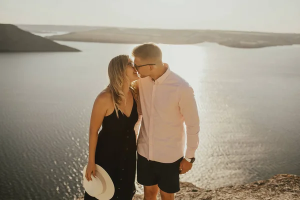 Man och kvinna i kärlek gå på ett berg ovanför en stor sjö hav — Stockfoto