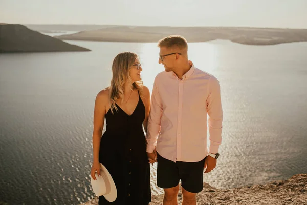 Man en vrouw in liefde lopen op een berg boven een groot meer zee — Stockfoto