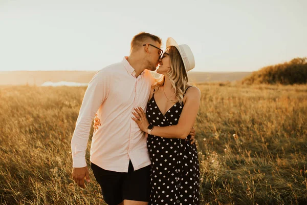 Jongen met een meisje in hoed wandelen in weide — Stockfoto