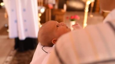 Bebek vaftiz ailesinin kollarında.