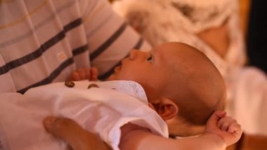 Bebek vaftiz ailesinin kollarında.