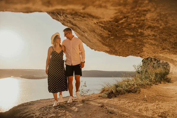 Muž a žena v klobouku procházka podél skal nad útesem — Stock fotografie