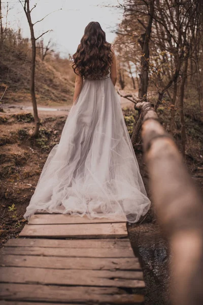 Schwangere in Gebirgsnähe spaziert über Holzbrücke — Stockfoto