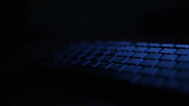 Un teclado de ordenador en la noche oscura en azul LUZ — Vídeos de Stock