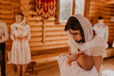 Ayin ayini, aydınlanma ayini. Anne kucağında yeni doğmuş bir çocuk var.