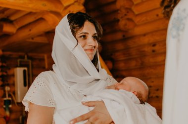 Ayin ayini, aydınlanma ayini. Anne kucağında yeni doğmuş bir çocuk var.