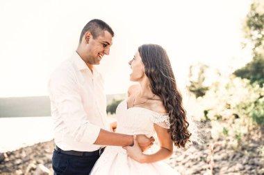 Gelin ve damat gülerek yazın batan güneş ışınlarına karşı birlikte koşarlar. 