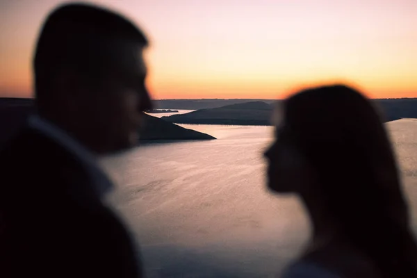 Gece gelin ve damadın siluetleri göl ve adalara karşı