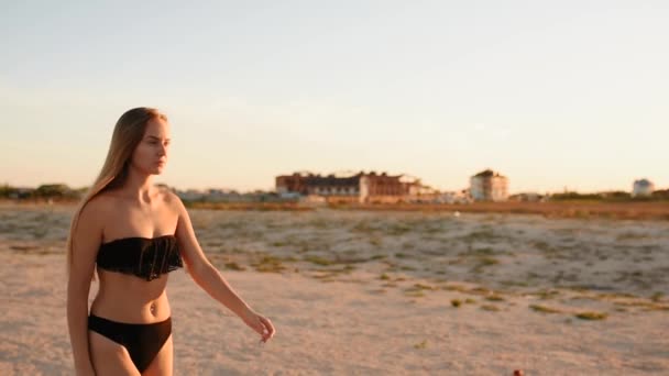 Mujer en bikini negro en la playa pone en máscara médica protectora en la cara — Vídeos de Stock