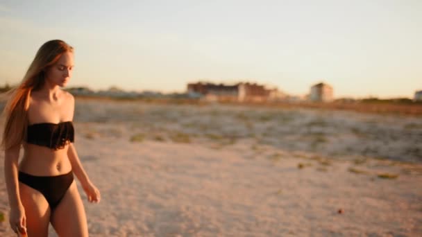 Mulher de biquíni preto na praia coloca em máscara médica protetora no rosto — Vídeo de Stock