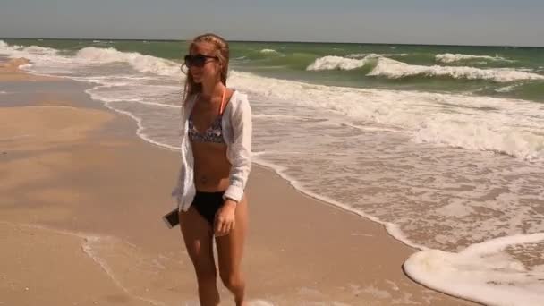 Sexy femme heureuse reposant sur la plage courir en maillot de bain bikini avec le téléphone à la main — Video
