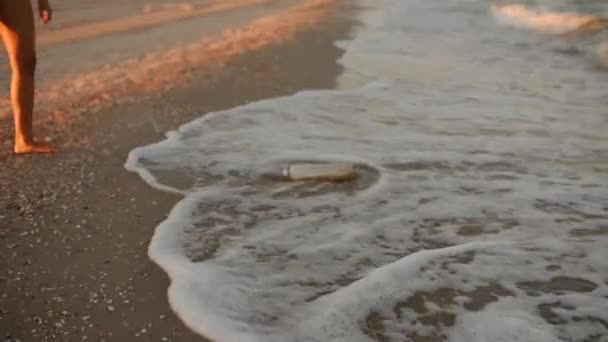 Invertire il video Donna raccoglie rifiuti d'acqua. onde del mare hanno portato rifiuti rifiuti di plastica sulla costa sabbiosa — Video Stock