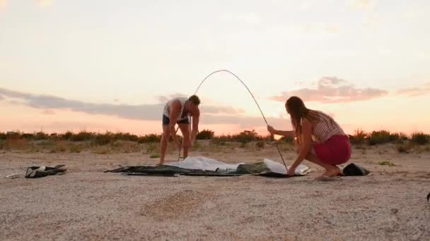 Una pareja de familias pone tienda de campaña turística en la playa juntos de camping. vídeo acelerado. lapso de tiempo — Vídeos de Stock