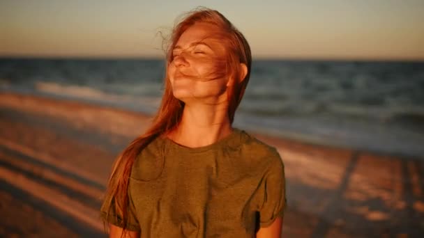 Ευτυχισμένη γυναίκα γελάει στη θάλασσα στην παραλία το ηλιοβασίλεμα. κοντινή προβολή — Αρχείο Βίντεο