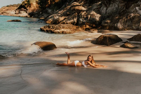 Mujer europea en bikini blanco bañador en la playa se encuentra en la playa de arena mar —  Fotos de Stock