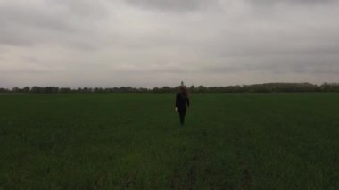 Kadın, virüslerden korunan koruyucu bir maskeyle yeşil bir alanda koşuyor.