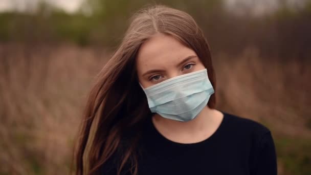 Wanita bertopeng pelindung rambut berkibar-kibar dalam pandemi angin covid-19 Coronavirus — Stok Video