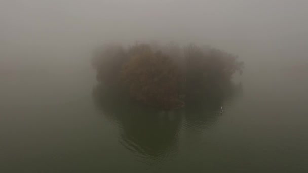 Samotny człowiek unosi się na desce na rzece w bardzo gęstej mgle — Wideo stockowe