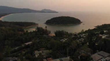  Hava aracı gün batımından sonra orman ve denizin üzerinde uçuyor.