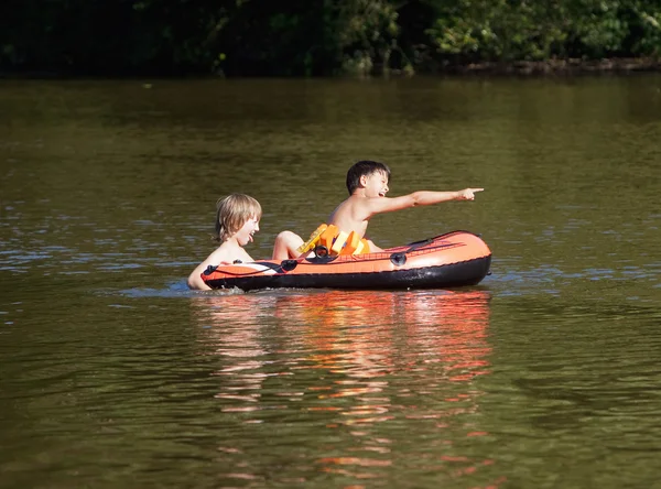 Deux garçons s'amusent sur un bateau en caoutchouc gonflable — Photo