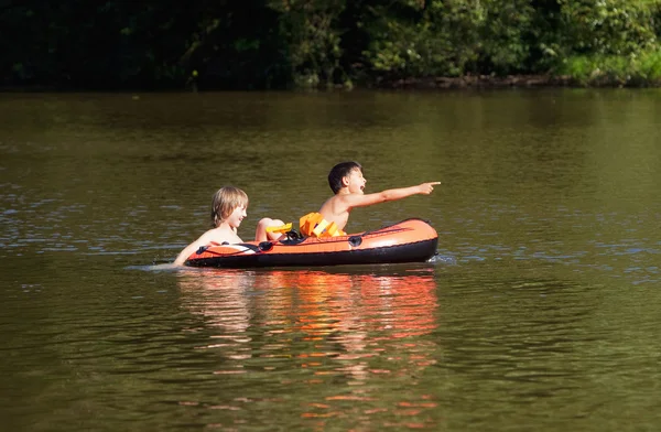 Twee jongens plezier op opblaasbare rubberboot dobbert — Stockfoto