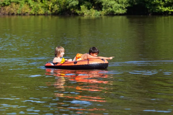 Dois meninos se divertindo no barco de borracha inflável — Fotografia de Stock