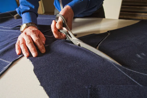 Tailor Cutting Fabric with Scissors . — стоковое фото