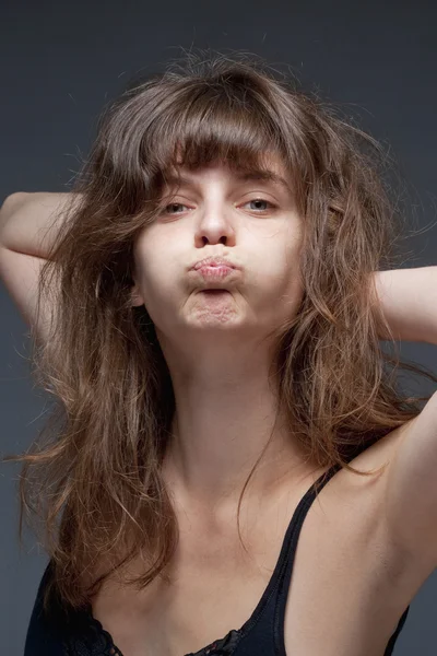 Mujer joven con el pelo castaño haciendo una cara — Foto de Stock