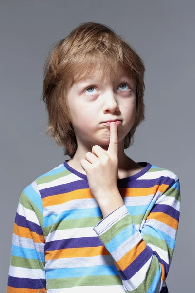Pojke söker tänkande, finger på munnen — Stockfoto