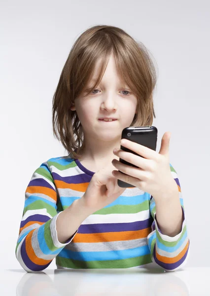 Niño leyendo el mensaje de texto en el teléfono móvil —  Fotos de Stock